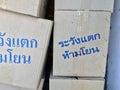 Stack of paper box, grey color and blue color of text in Thai language Ã¢â¬ÅWarning! Fragile, do not throwÃ¢â¬Â. Royalty Free Stock Photo